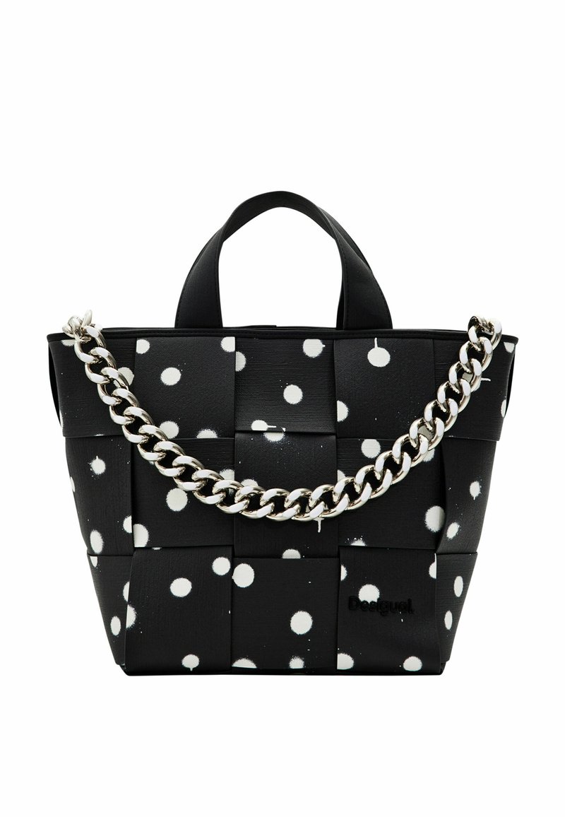 Sac tissé noir avec des pois blancs, doté de doubles poignées supérieures et d'une chaîne argentée épaisse. Fini lisse, forme rectangulaire, logo de la marque visible.