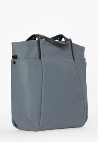 Grå vandtæt tote bag med sorte accenter, der har to udvendige lommer, et struktureret design og forstærkede hanke.