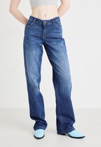 Ανοιχτό μπλε παντελόνι ψηλόμεσο ίσιας γραμμής με κλασσικό σχέδιο πέντε τσεπών, ελαφρά φθορά και κουμπί στη μέση.