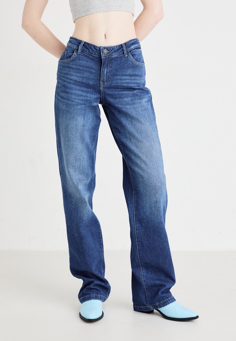 Ανοιχτό μπλε παντελόνι ψηλόμεσο ίσιας γραμμής με κλασσικό σχέδιο πέντε τσεπών, ελαφρά φθορά και κουμπί στη μέση.