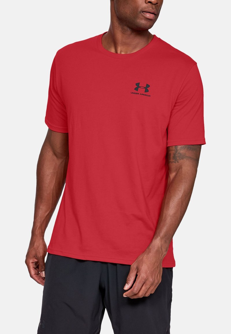 T-shirt rouge à manches courtes en tissu doux, avec un col rond et un petit logo noir Under Armour sur la poitrine.