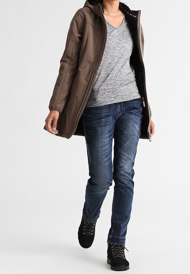 Veste marron à capuche avec une fermeture éclair et une doublure en polaire. Portée par-dessus un t-shirt gris chiné et un jean bleu. Bottes noires à lacets.