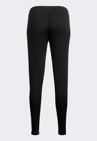 Leggings negros con una textura suave y una cinturilla elástica, que presentan un diseño ajustado que se estrecha en los tobillos.