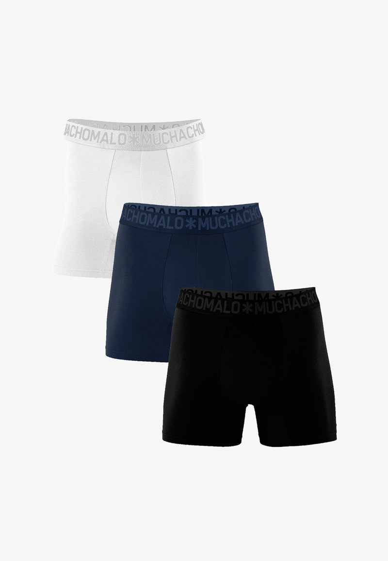 Three pairs of boxer shorts in white, navy, and black. Each features a soft, elastic waistband with "MUCHACHO" text. Smooth fabric and fitted design.