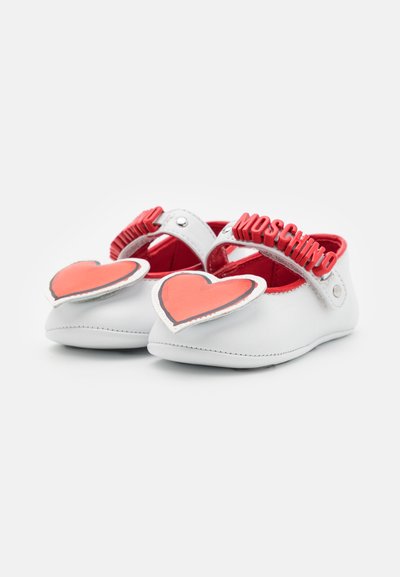 White leather baby shoes with red accents, featuring heart-shaped appliqués, a logo strap, and a soft sole for comfort.