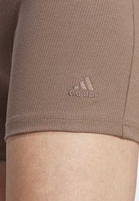 adidas Sportswear LOUNGE RIBBED HIGH-WAIST BIKE - Tights - earth strata