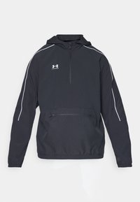 Black pullover jacket with a hood, half zip, and front pocket; features white accent stripes and an Under Armour logo on the chest.