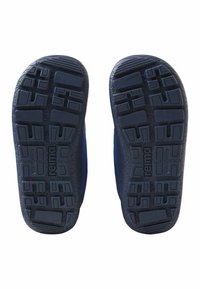 Widok podeszwy niebieskich butów slip-on z teksturowanymi wzorami antypoślizgowymi i brandingiem "reima" na każdej podeszwie, izolowanych na białym tle.