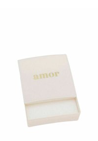 Scatola rettangolare di colore avorio, con una superficie liscia, sulla cui parte superiore è riportata la parola "amor" in lettere dorate. Interno vuoto.