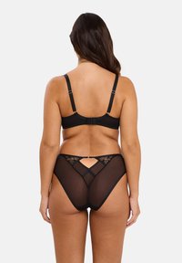 Ensemble de lingerie noire comprenant un bralette avec des bretelles réglables et un dos accentué de dentelle, associé à des culottes transparentes taille basse.