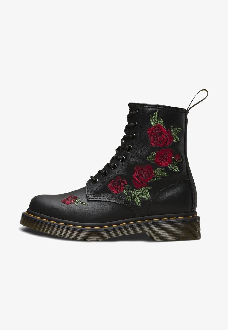 Stivale in pelle nera con chiusura a lacci, ricamo di rosa rossa e foglie verdi, suola spessa con cuciture gialle e linguetta sul retro.