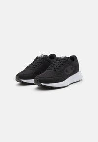Sneaker nere da atleta con un mix di materiali in rete e camoscio, punta tonda, design con lacci e una suola intermedia bianca con una suola esterna nera testurizzata.
