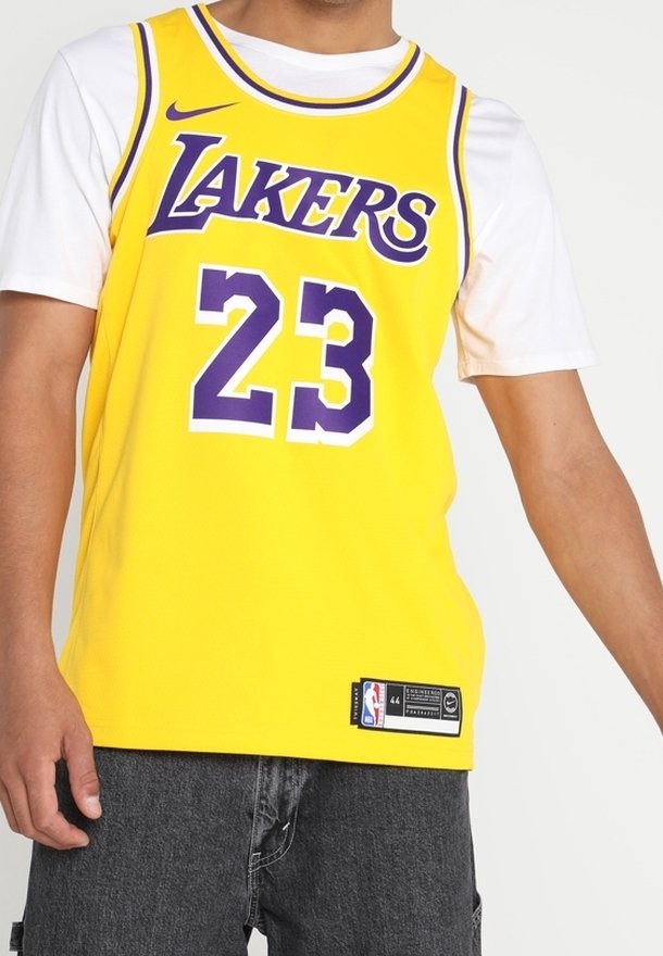 Maillot de basket jaune avec "LAKERS" et le numéro "23" en violet. Logo Nike sur l'épaule gauche, étiquette sur l'ourlet inférieur, design sans manches.