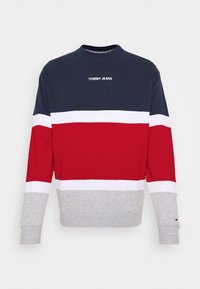 Mikina s kulatým výstřihem s barevnými bloky v námořnické modré, bílé, červené a šedé barvě, se znakem "TOMMY JEANS" na hrudi a malým logem na manžetě levého rukávu.