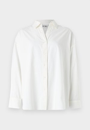 Fehér, pamut anyagú, gombos ing. Galléros nyakkivágással, hosszú ujjakkal és laza szabással rendelkezik. Simább textúrával, látható minták nélkül.