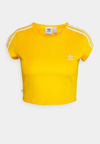 Jasně žluté zkrocené tričko Adidas s bílými třemi pruhy na rukávech a malým bílým logem Adidas na levé hrudi.
