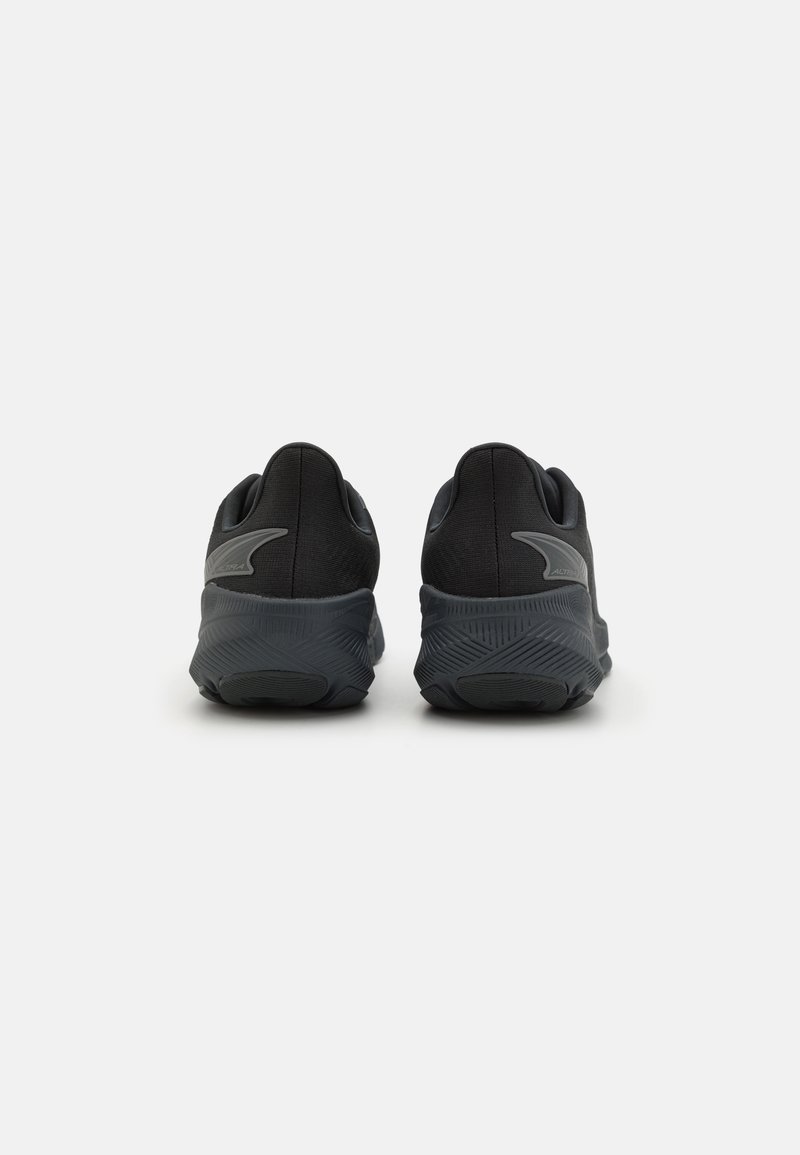 Zapatillas deportivas negras con parte superior de tela texturizada, suela acolchada y sutiles detalles en gris en el talón y el logo.