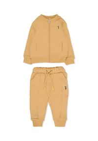Completo di felpa gialla in cotone con zip e tasche laterali, abbinato a pantaloni jogger con vita elasticizzata e cuciture laterali.