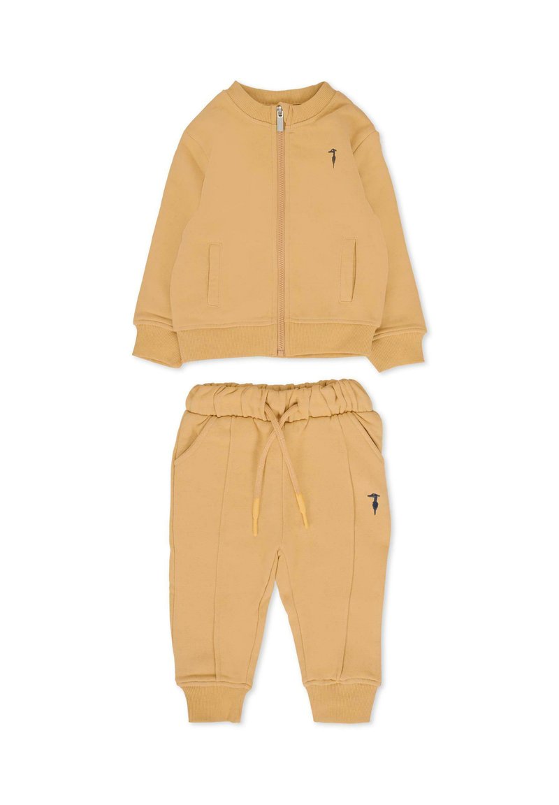 Completo di felpa gialla in cotone con zip e tasche laterali, abbinato a pantaloni jogger con vita elasticizzata e cuciture laterali.