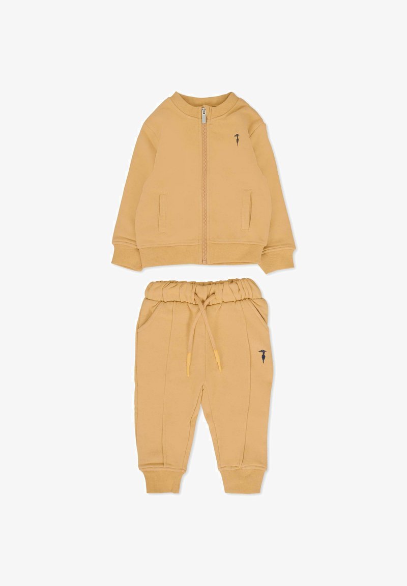 Geel katoenen trainingspak met een ritsjack met zijzakken en bijpassende joggers met een elastische tailleband en zijnaad.