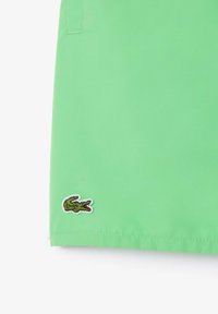 Groene katoenen shorts met een gladde textuur, met een geborduurd krokodillenlogo in contrasterende kleuren aan de zoom.