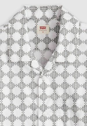 Kortærmet skjorte i hvid bomuld med et sort abstrakt mønster, knaplukning foran og åben krave. Levi's label synlig.