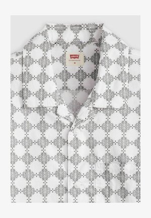 Lyhythihainen valkoinen puuvillapaita, jossa on musta abstrakti kuvio, napitettu etuosa ja avoin kaulus. Levi's-tunnus näkyvissä.