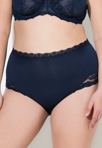 Navy blauwe hooggesneden onderbroek van gladde stof, met kant aan de taille en zijkanten, met een klassieke snit en een ondoorzichtige uitstraling.