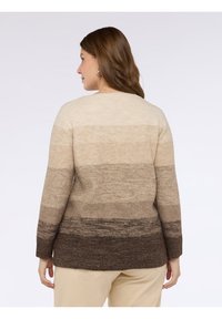 Stickad tröja med ett gradientmönster från ljusbeige till mörkbrun, långa ärmar och rund halsringning, tillverkad av mjuk tyg.