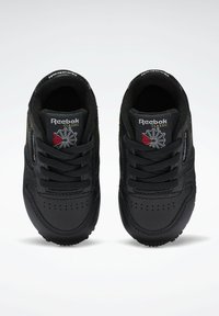 Svart Reebok Classic sneakers med övre i slätt läder, snörningsdesign, vadderad krage och logotypdetalj på tungan. Rund tåform och texturerad sula.