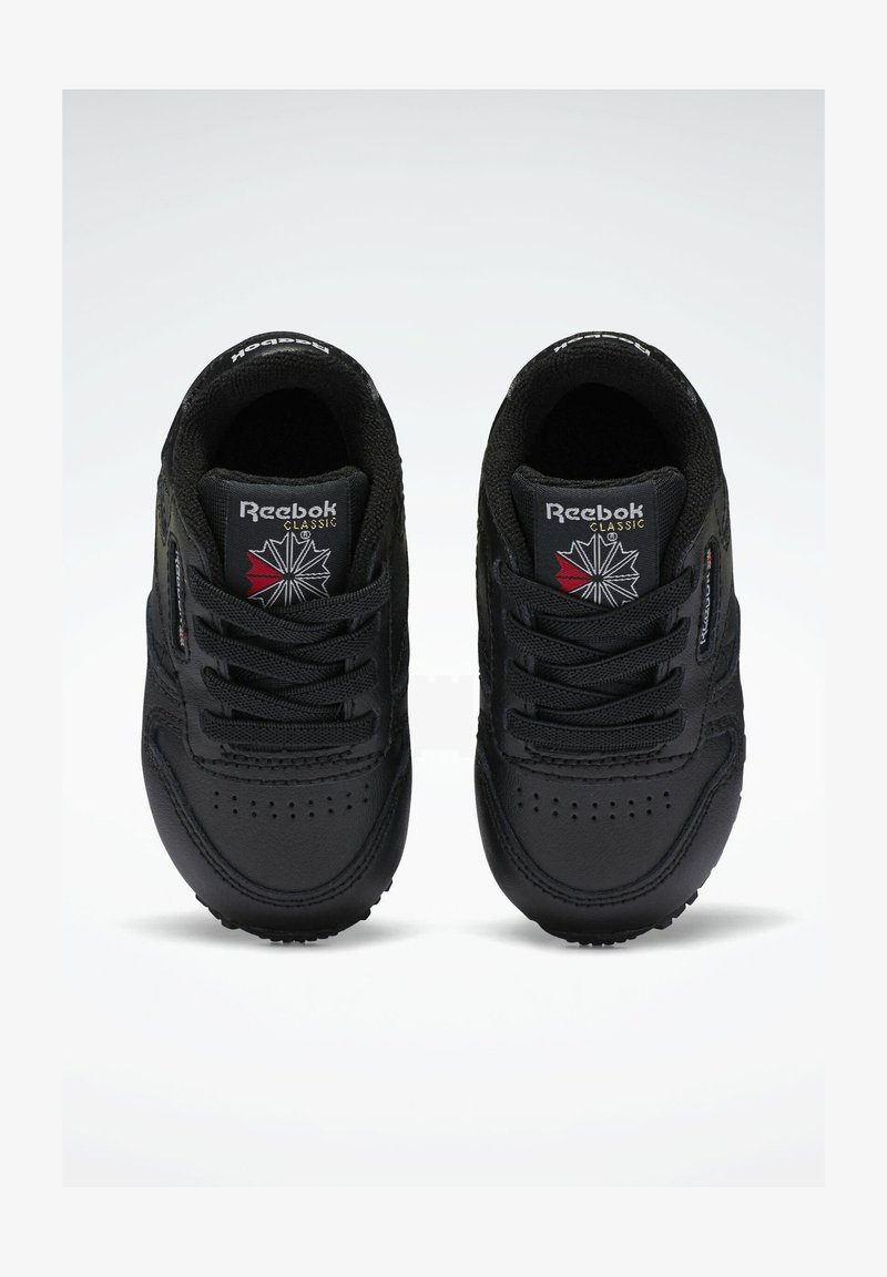 Sorte Reebok Classic sneakers med glatt læroverdel, snøring, polstret krage og logo-detalj på tungen. Rund tåform og strukturert såle.