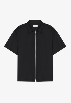 Chemise noire à manches courtes avec un col net et une fermeture éclair sur le devant. Tissu lisse avec un léger éclat, sans motifs ni accents visibles.