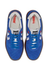 Baskets en suede bleu avec des accents blancs, dotées d'une semelle en caoutchouc, d'un motif texturé et de lacets bleus contrastants. Marque visible sur la languette.