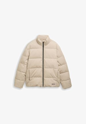 Bežna tilna puhovka s podloženim vodoravnim šivi, ovratnikom, ki se dvigne, črn zadrgo na sprednji strani in majhnim besedilnim logotipom blizu roba.