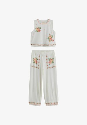 Weißes ärmelloses Top und Hose mit pinker und gelber Blumenstickerei auf Brust, Taschen, Saum und Ausschnitt.