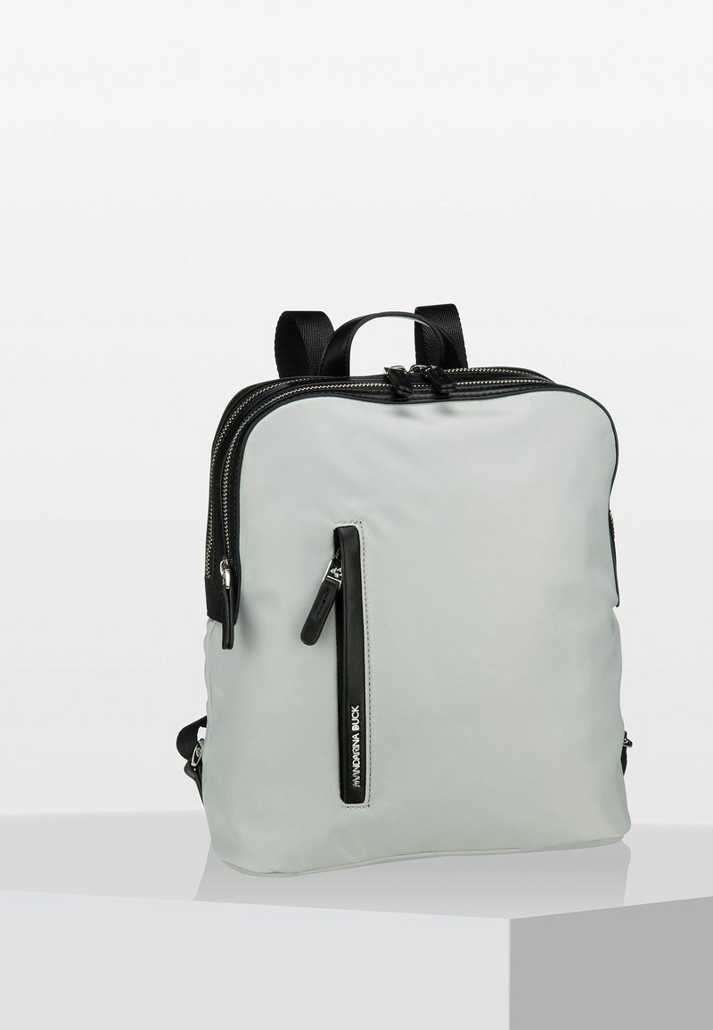 Sac à dos en nylon gris avec des zips et des accents noirs. Forme rectangulaire, bretelles ajustables, poche zippée à l'avant et détails texturés.