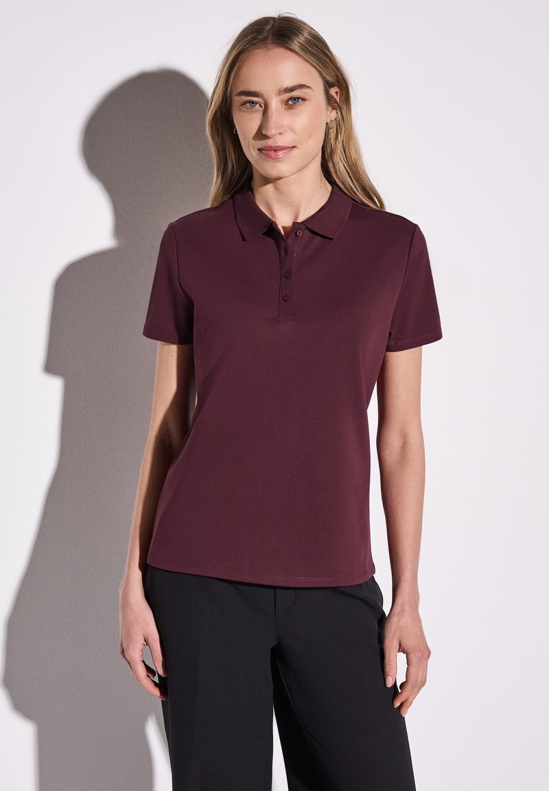Burgundy polo skjorta med krage, treknapps stängning och korta ärmar, tillverkad av slät, strukturerad tyg.