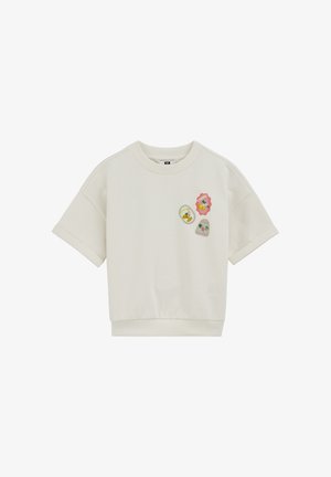 Biała bluza z krótkim rękawem, z podwiniętymi mankietami i trzema kolorowymi naszywkami z motywem owocowym na górnej lewej stronie klatki piersiowej.