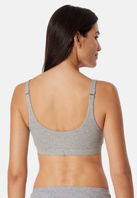 Harmaa puuvillainen bralette leveillä olkaimilla, kaarroke-back-muotoilulla ja elastisella vyöllä. Pehmeä rakenne, saumaton viimeistely ja ei näkyvää metalliosaa.