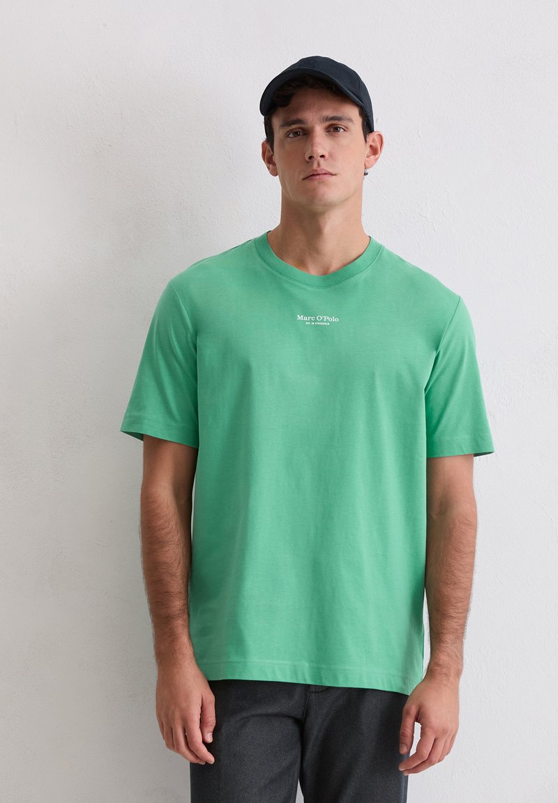 Zielony, bawełniany T-shirt z krótkim rękawem, z okrągłym dekoltem i białym logo nadrukowanym na piersi. Gładka faktura, luźny krój.