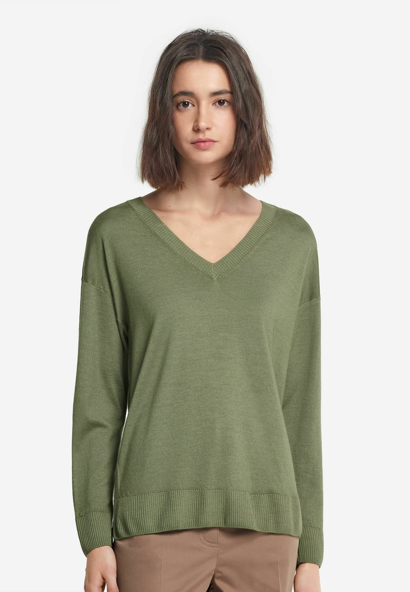 Olivengrøn sweater med V-hals, lange ærmer og ribbet kant. Lavet af blødt stof, med en afslappet pasform og glat tekstur.