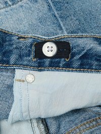 Tejido de denim en azul claro con una cinturilla azul oscura. Presenta un botón plateado y detalles de costura. Textura suave con un desvanecimiento sutil.