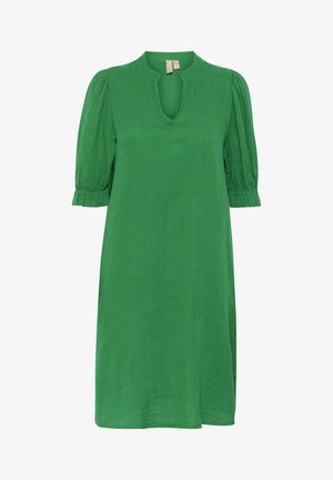 Vihreä mekko, joka on valmistettu kevyestä kankaasta, V-pääntie, lyhyet puffihihat ja koottu hihansuu. Silkkinen tekstuuri ja polvipituinen malli.