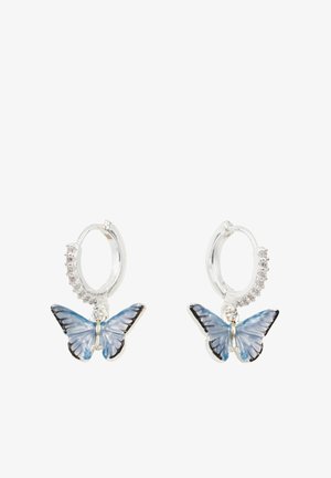 Sudraba riņķa auskari ar ziliem tauriņu piekariņiem, kuriem ir melnas malas. Riņķi ir akcentēti ar mazām caurspīdīgām kristālu.