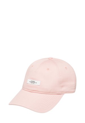 Pink cotton baseball cap with a curved brim, featuring a white logo patch on the front and ventilation eyelets on the crown.