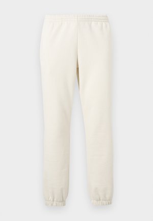 Pantalon de jogging beige avec taille élastique et chevilles élastiques, présenté à plat sur un fond clair.