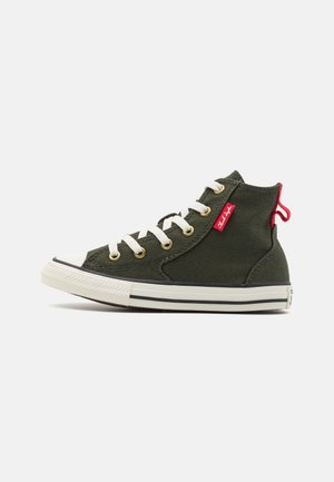 High-Top Sneaker aus olivgrünem Canvas mit weißen Schnürsenkeln, Gummisohle, goldenen Ösen und rotem Markenschild nahe dem Knöchel auf weißem Hintergrund.
