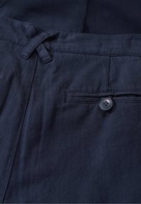 Marineblauwe broek van textuurstof, met een knoopzak aan de achterkant en een geweven trekkoord in de tailleband.
