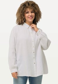 Witte button-up shirt in textiel met structuur, voorzien van een klassieke kraag, lange mouwen en parelachtige knopen. Ontspannen, oversized pasvorm.