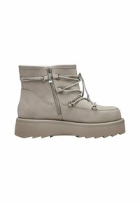 Bottine beige avec une tige en cuir texturé, présentant des accents métalliques, une fermeture éclair sur le côté et une semelle en caoutchouc épaisse avec un design à rayures.